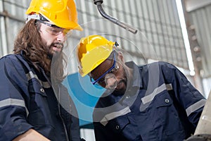 Two engineer man working with machine robot automatic together at factory, technician maintenance and improvement.