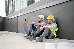 Two engineer or technician workers use mobile phone to selfie after finish work in construction site