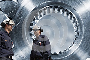 Two engineers and cogwheels axle