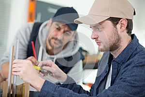 two engineers discussing plans with cmm arm in foreground