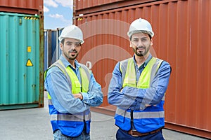 two Engineers or foreman container cargo wearing white hardhat and safety vests checking stock into container for loading from