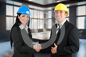 Two engineers with helmets shake hands