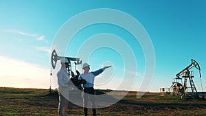 Two engineers inspecting oil field equipment