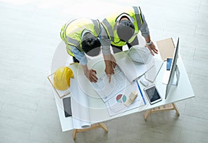 Two engineers man looking at blueprint drawing project plan on the table