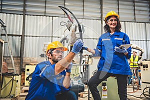Two engineers mechanic using computer controller Robotic arm for welding steel in steel factory workshop. Industry robot