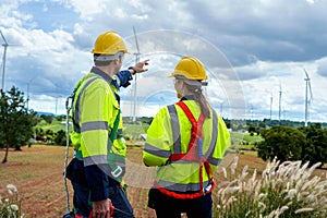 Two engineers plan on-site inspection and maintenance of wind turbines