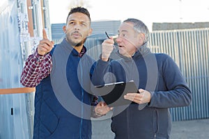 Two engineers smiling outside in shipping yard