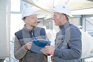 two engineers in uniform and helmets talking outdoors