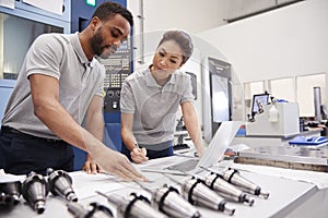 Two Engineers Using CAD Programming Software On Laptop