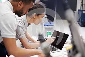 Two Engineers Using CAD Programming Software On Laptop