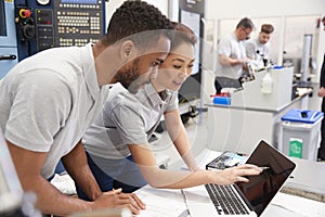 Two Engineers Using CAD Programming Software On Laptop