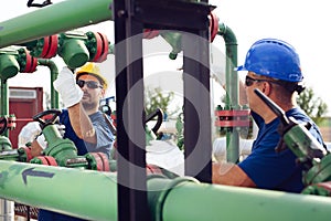 Two engineers working inside oil and gas refinery