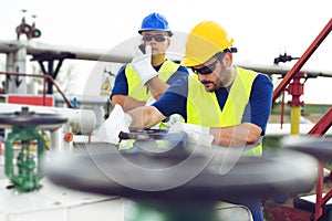 Two engineers working inside oil and gas refinery