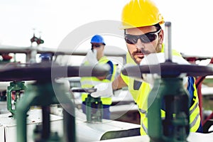 Two engineers working inside oil and gas refinery