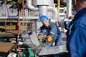 Two engineers working inside oil and gas refinery