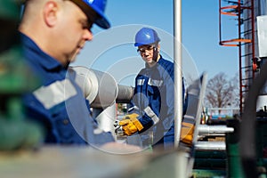 Two engineers working inside oil and gas refinery