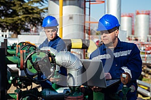 Two engineers working inside oil and gas refinery