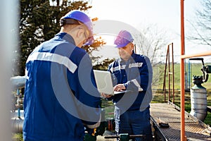 Two engineers working inside oil and gas refinery