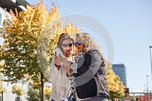 Two enterprising women are reviewing and commenting on something they see on a tablet