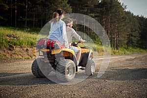 Two enthusiastic friends driving quad together