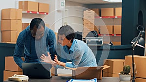 Two entrepreneurs checking supply chain on storehouse shelves