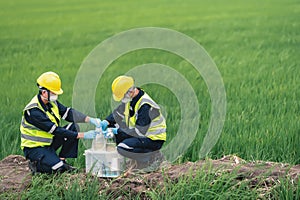 Two Environmental Engineers Take Water Samples at Natural Water Sources Near Farmland Maybe Contaminated by Toxic Waste or