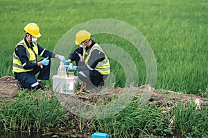 Two Environmental Engineers Take Water Samples at Natural Water Sources Near Farmland Maybe Contaminated by Toxic Waste or