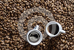 Two espresso cup on coffee beans background above