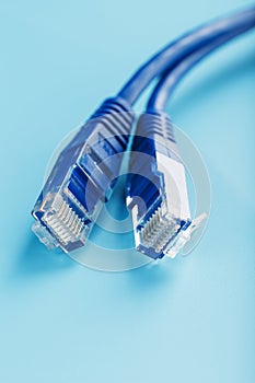 Two Ethernet Cable Connectors Patch cord cord close-up isolated on a blue background with free space