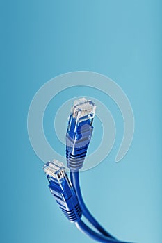 Two Ethernet Cable Connectors Patch cord cord close-up isolated on a blue background with free space