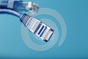 Two Ethernet Cable Connectors Patch cord cord close-up isolated on a blue background with free space