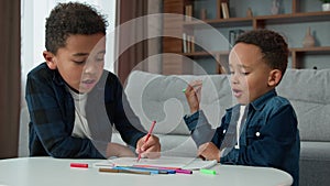 Two ethnic African American boys kids enjoy hobby art at home homework draw schoolboys brothers pupils siblings children