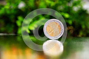 Two euro coin closeup on silver and green background