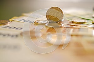 two euro coins and Two hundred euro banknotes on a green background.Expenses and incomes in European countries. Finance