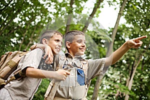 Two excited boys on a camping trip in the forest exploring