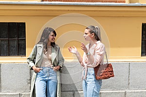 Two excited happy hipster cool women walking together on the street. High Fashion amazed model woman posing in city street. Happy