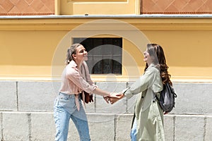 Two excited happy hipster cool women walking together on the street. High Fashion amazed model woman posing in city street. Happy