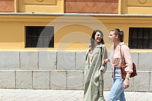 Two excited happy hipster cool women walking together on the street. High Fashion amazed model woman posing in city street. Happy