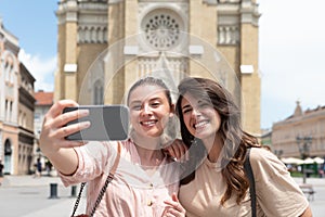 Two excited happy hipster cool women walking together on the street. High Fashion amazed model woman posing in city street. Happy