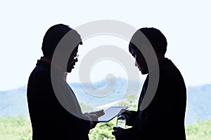 Two executive businessmen discussing over a project on a compute