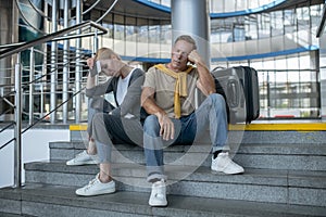 Two exhausted tourists dozing at the airport terminal