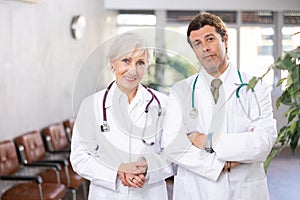 Two experienced professional doctors standing in medical office