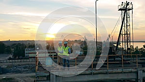 Two experts are standing at the loading platform and looking around