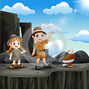 Two explorer kid on the cliff with a bird