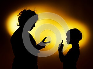 Two expressive boy's silhouettes showing emotions using gesticu photo