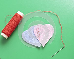two fabric hearts sewn together on a green background