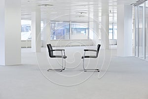 Two facing chairs in empty office space