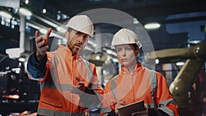 Two factory specialists controlling work machinery at production close up.