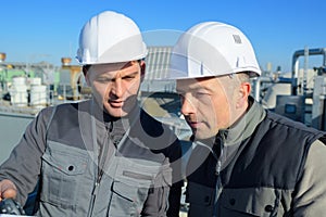 Two factory workers discussion and pointing for inspection