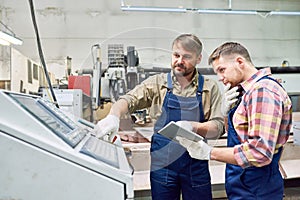 Two Factory Workers Operating Machines